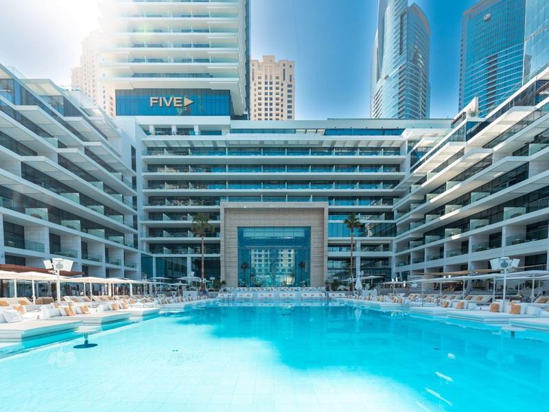 Modern hotel with large swimming pool and surrounding sun terraces in the city