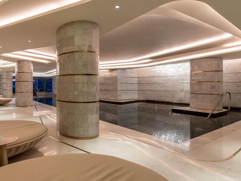 Modern indoor pool with round columns and indirect lighting in a luxurious hotel