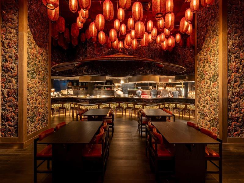 Cozy restaurant with warm lighting and intricate wood carvings on the walls.