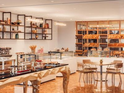 Moderní snídaňový bufet s výběrem chleba a posezením v elegantní místnosti.