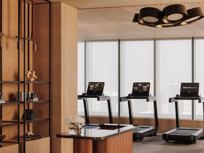 Modernes Fitnessstudio mit Laufbändern und stilvoller Holzverkleidung in einem Hotel.