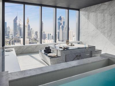 Luxurious bathroom with large bathtub and view of modern skyscrapers.