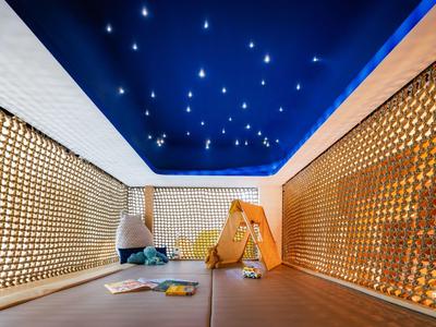 Modern relaxation room with starry sky ceiling and cozy seating areas.