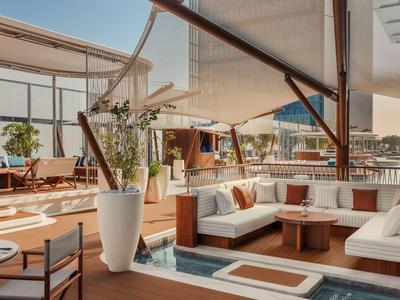 Modern rooftop terrace with cozy seating areas, plants, and city views.