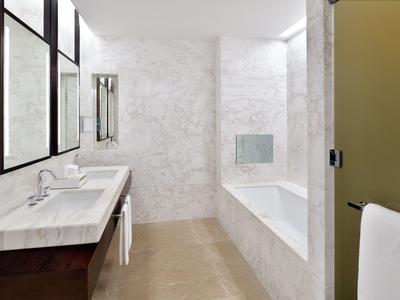 Modernes Bad mit Doppelwaschbecken, Badewanne und großen Fenstern mit Rahmen aus dunklem Holz.