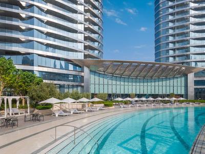 Salon d'hôtel moderne avec vue sur la skyline d'une ville par ciel clair.