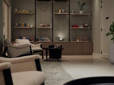 Espace lounge d'hôtel moderne avec étagères, fauteuils et grande plante en pot.