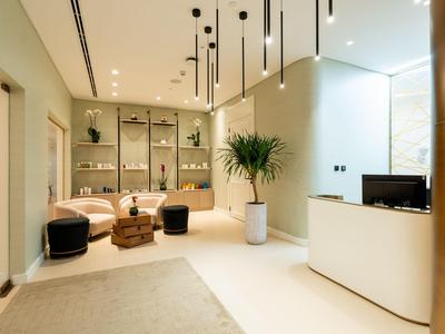 Modern hotel lobby with seating, plants, and sleek reception desk.