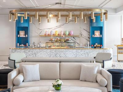 Elegante hotel lobby met comfortabele zitplaatsen en een moderne bar op de achtergrond.