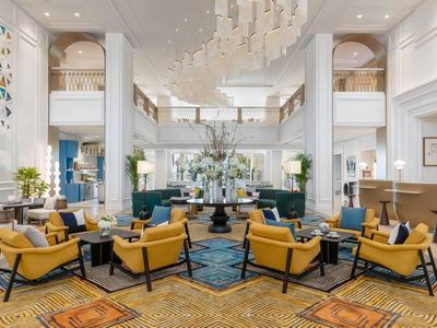 Elegant hotel lounge with yellow armchairs, modern design, and chandeliers