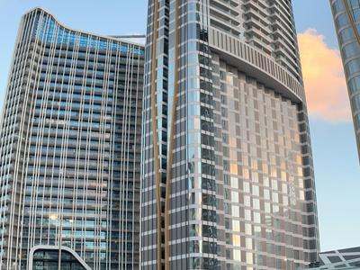 Hohe moderne Glasgebäude mit vielen Fenstern und strukturierter Fassade im Stadtzentrum.