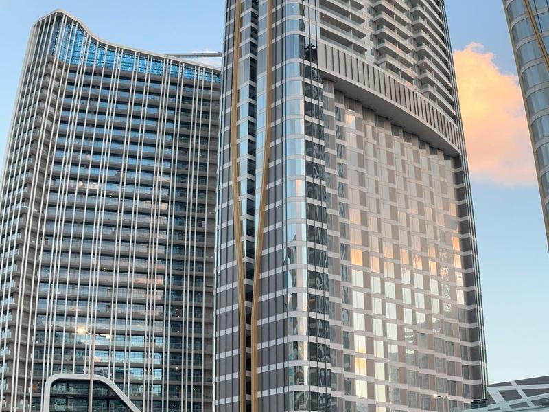 Hohe moderne Glasgebäude mit vielen Fenstern und strukturierter Fassade im Stadtzentrum.