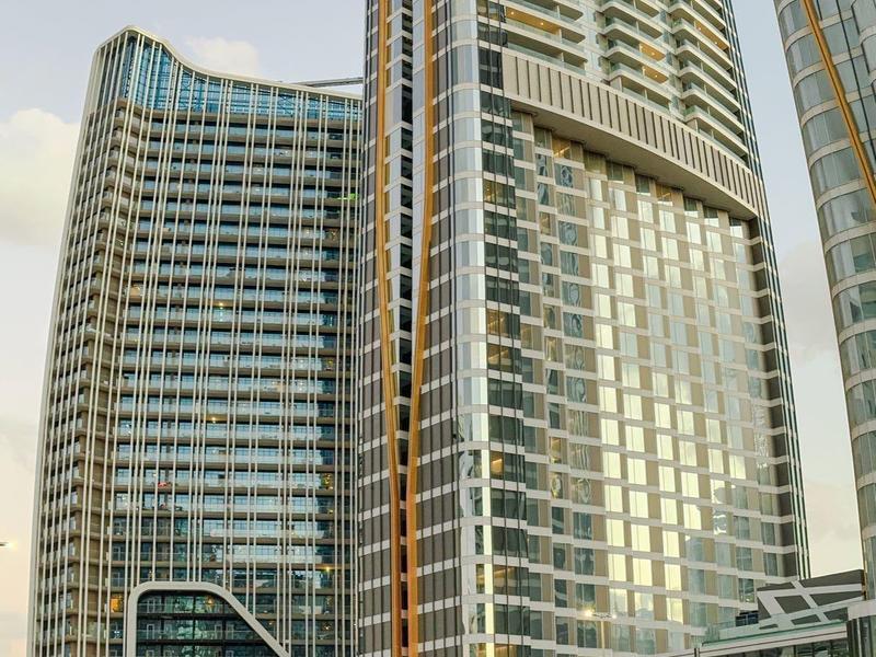 Moderne hohe Glasgebäude mit reflektierenden Fenstern in einem urbanen Stadtgebiet.