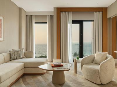 Nowocześnie urządzone salon z jasnymi meblami i widokiem na naturę przez duże okna.