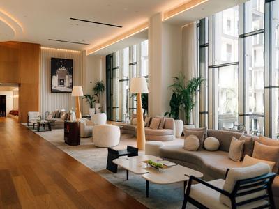 Heller, moderner Hotellobby-Bereich mit großen Fenstern, bequemen Sofas und Holzboden.