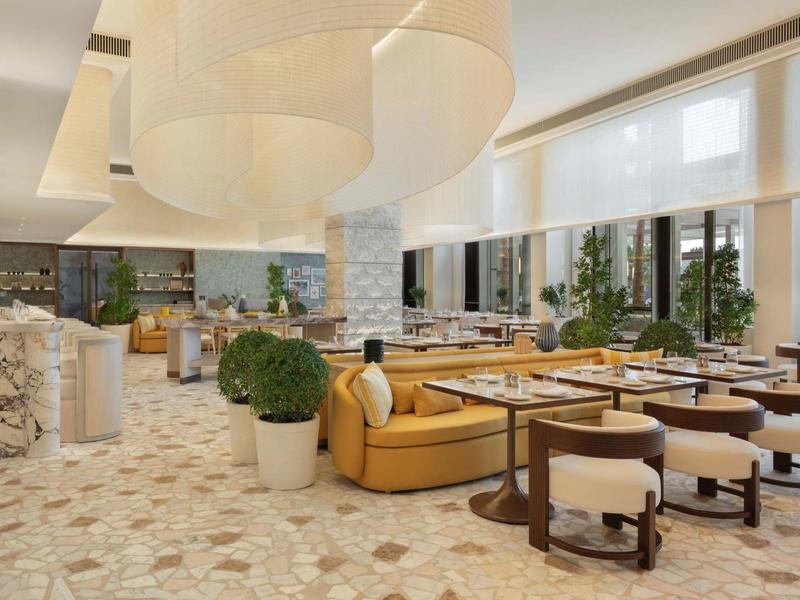 Nowoczesna strefa restauracyjna w hotelu z wygodnymi fotelami i dużymi oknami.