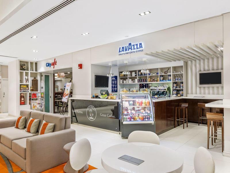 Modern café met gezellige zitplaatsen en een koffiemachine in een hotel.