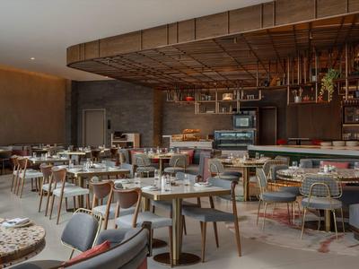 Espace restaurant moderne avec tables dressées et plafond en bois au design élégant.