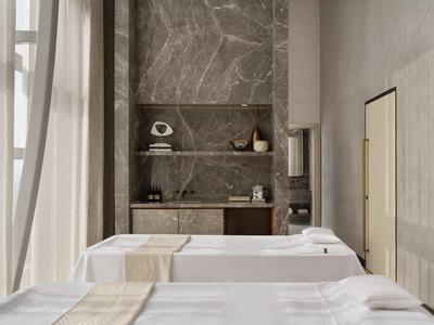 Salle de massage lumineuse avec deux tables blanches et de grandes fenêtres.