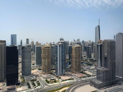 Gratte-ciel modernes dans un paysage urbain animé sous un ciel dégagé.