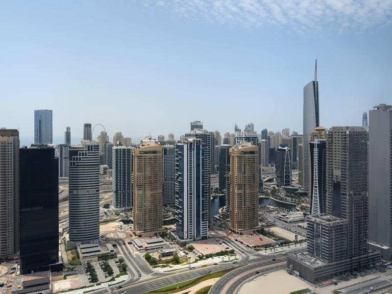 Gratte-ciel modernes dans un paysage urbain animé sous un ciel dégagé.