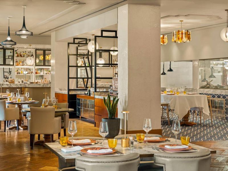 Modern eingerichtetes Restaurant mit elegant gedeckten Tischen und warmem Licht.