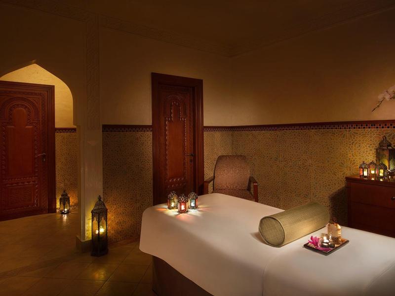 Gemütlicher Massageraum mit zwei Tischen, warmem Licht und entspannender Atmosphäre.