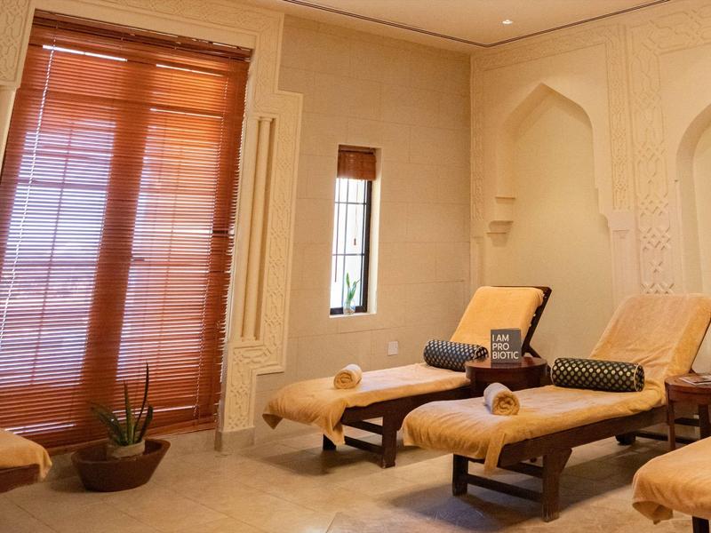 Gemütlicher Wellnessraum mit zwei Liegen, warmen Holztönen und weichen Stoffen.