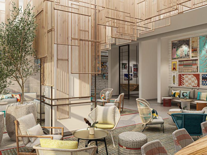 Moderní posilovna s běžeckými pásy a cvičebními stroji vedle velkých oken s výhledem ven.