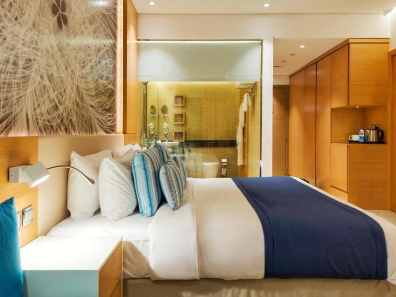 Modernes Hotelzimmer mit Doppelbett, blauen Akzenten und Holzmöbeln.