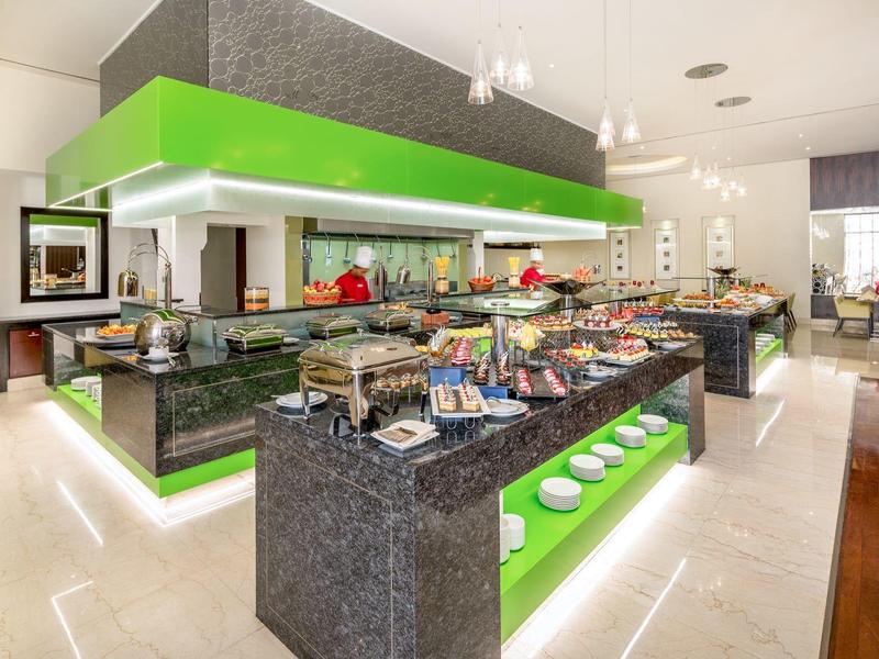 Modern buffet with diverse dishes in bright, stylish hotel setting.