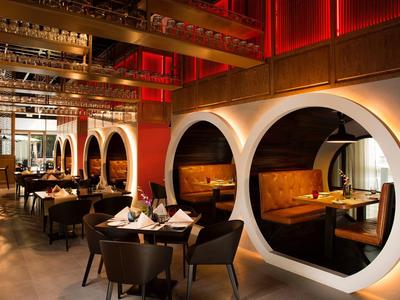 Modern restaurant area with round illuminated niches and elegantly set tables.