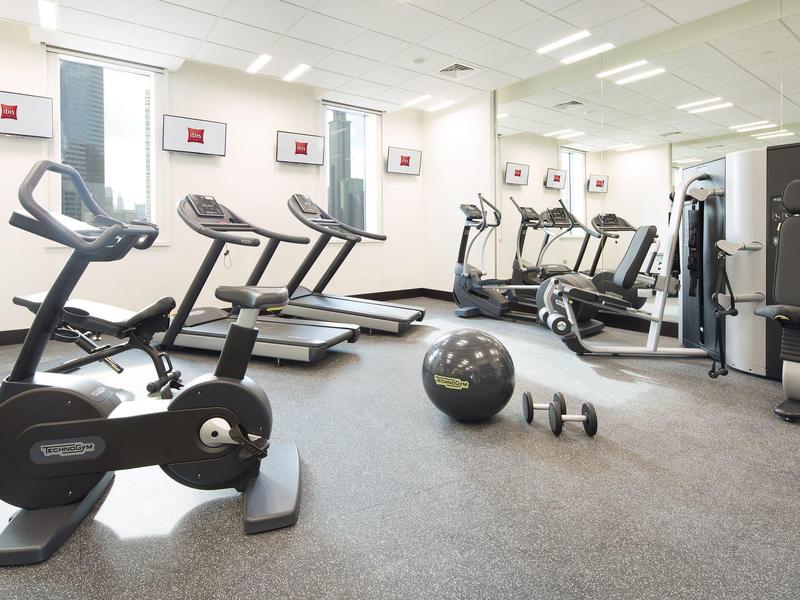 Brightly lit gym with treadmills, bikes, and exercise equipment.