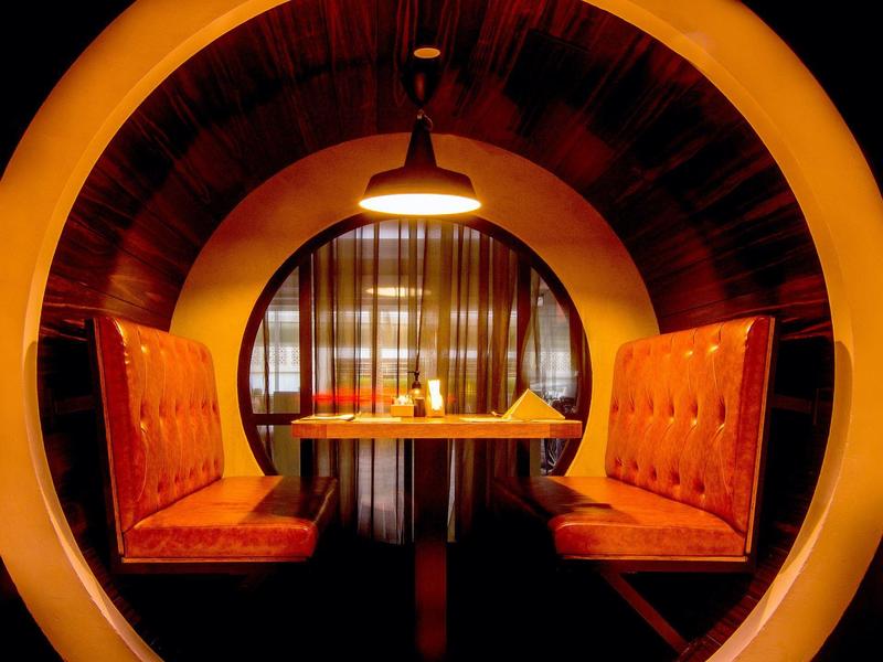 Cozy booth with brown upholstered seats and warm lighting in a restaurant.