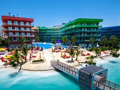 Bunte Hotels am türkisblauen Meer mit Sandstrand und Liegen