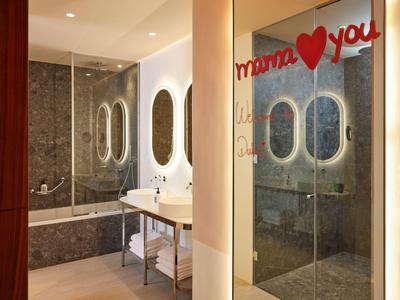 Modernes Badezimmer mit Dusche, Badewanne, Spiegeln und roter Dekoration "mama ♥ you" am Spiegel.