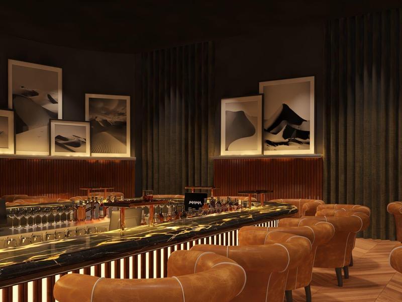 Elegant bar with brown leather chairs, indirect lighting, and art pictures on the walls.