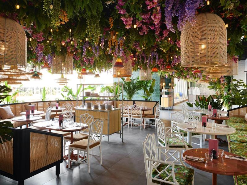 Cozy restaurant with lush floral ceiling and modern interior design.