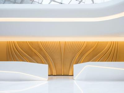 Moderní interiér s bílými lavicemi a dřevěným obkladem pod vlnitou střechou.