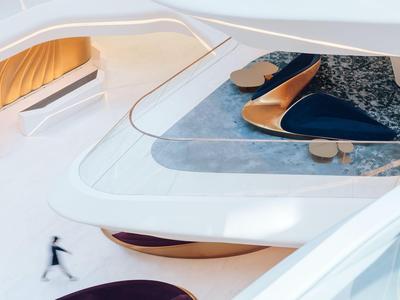 Moderní hotelový interiér s bílým zakřiveným schodištěm a betonovou podlahou