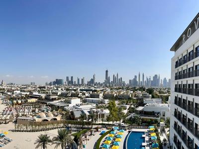 City skyline with beach resorts and a large hotel building under a clear sky.