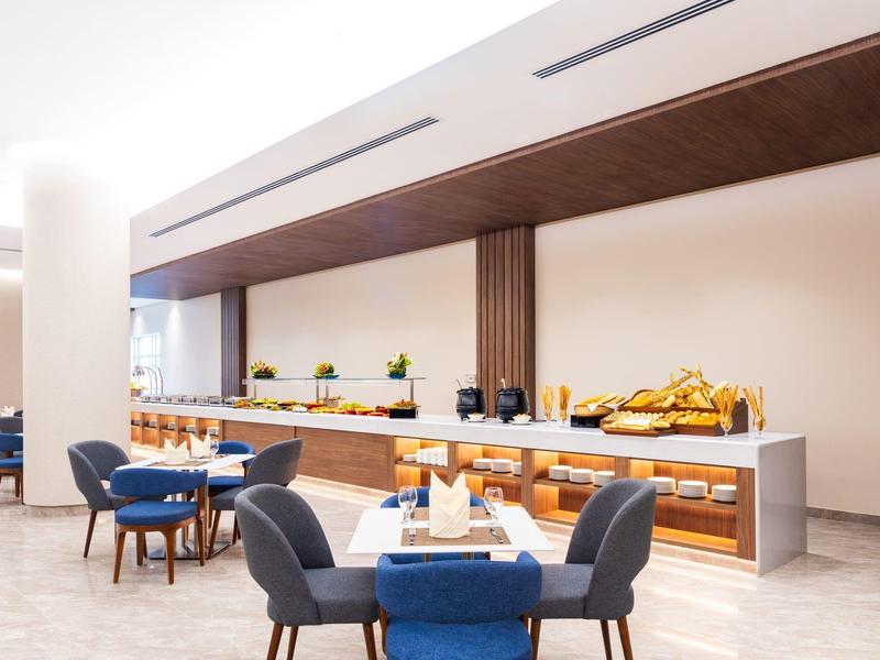 Moderní snídaňový bufet s posezením v elegantní hotelové restauraci.