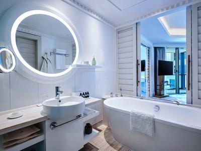 Salón elegante de hotel con sillones modernos, mesas y una alfombra azul llamativa.