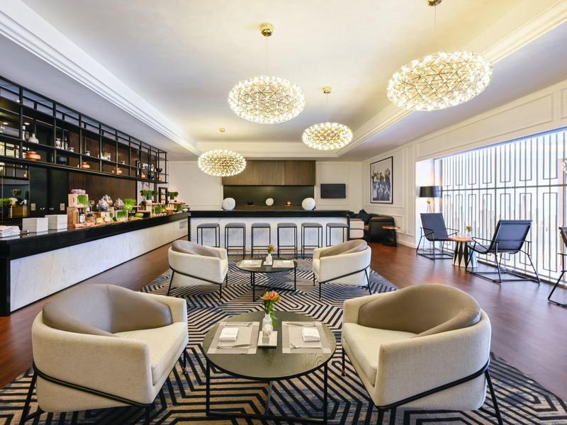 Moderna sala de estar de hotel con barra, sillones cómodos y gran ventana con vista exterior.