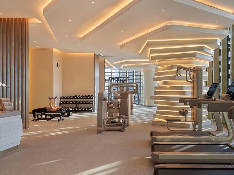 Bright, modern gym with treadmills and soft accent lighting.