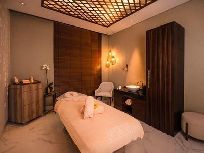 Cozy wellness room with massage table, warm lighting, and stylish furniture.