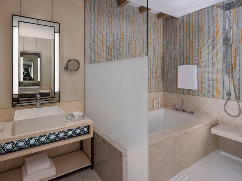 Moderní koupelna s vanou, sprchou a umyvadlem s velkým zrcadlem.