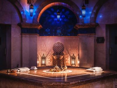 Luxe spa-ruimte met Marokkaans bad, kussens en sfeerverlichting.