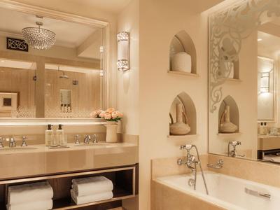 Elegant badkamer met bad, grote spiegel en stijlvolle verlichting.