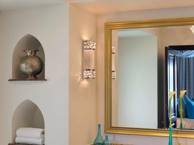 Elegante hotelbadkamer met grote spiegel, decor en handdoeken in nissen.